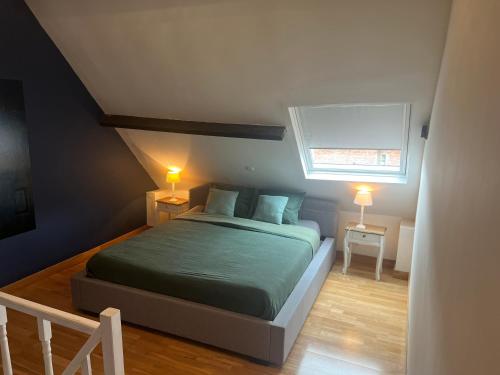 een slaapkamer met een bed, een raam en 2 lampen bij B&B DeSo in Zonnebeke