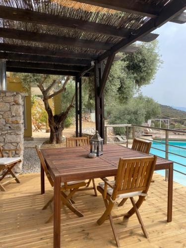 a wooden table and chairs on a wooden deck at Melolia Estate in Thiva
