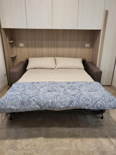 ein großes Bett mit einer blau-weißen Decke drauf in der Unterkunft Milano Vimodrone Appartamento Il nido in Vimodrone