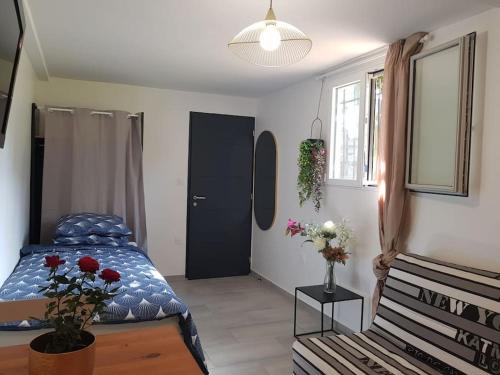 a bedroom with a bed and a table with flowers at Logement de charme et confort in Sceaux