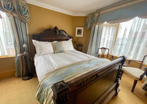a bedroom with a large bed in a room with windows at Ebenezer's Place in Broadstairs