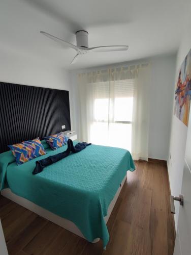 a bedroom with a green bed with a ceiling at ÁTICO TERESA BORA PALM, PISCINA PRIVADA CLIMATIZABLE 250m playa in Vera