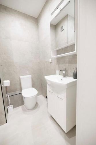 a white bathroom with a toilet and a sink at Green Eyes Deluxe,1BR Apartment in Sofia