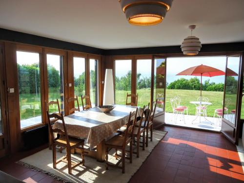 ein Esszimmer mit einem Tisch und Stühlen sowie eine Terrasse in der Unterkunft Villa with Lake Geneva views; 1960 (mid century modern) style in Neuvecelle