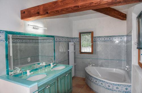 een badkamer met een bad, 2 wastafels en een bad bij Exclusive Villa in Provence with swimming pool in a very quiet private domain in Montauroux