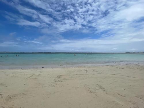 a beach with people swimming in the water at Hotel Costa Linda Beach Boca Chica in Boca Chica
