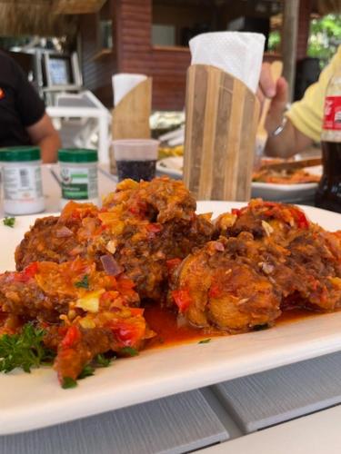 a plate of food with meat and vegetables on a table at Hotel Costa Linda Beach Boca Chica in Boca Chica