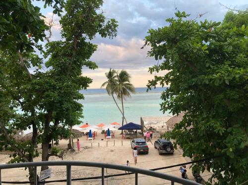 a view of a beach with cars and the ocean at Hotel Costa Linda Beach Boca Chica in Boca Chica