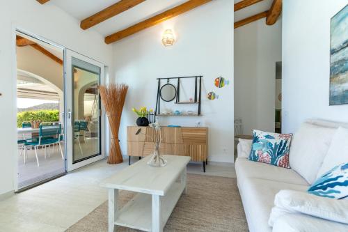 a living room with a white couch and a table at Villa Smeralda in San Teodoro