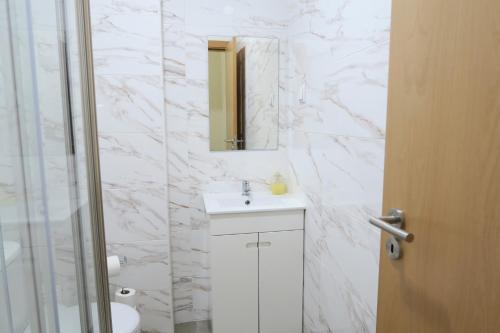 a white bathroom with a sink and a mirror at Lisbon Key Hub - Rooms 1-5 in Lisbon