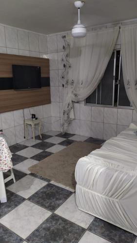 - une chambre avec un lit et un sol en damier dans l'établissement AP 35, à Praia Grande