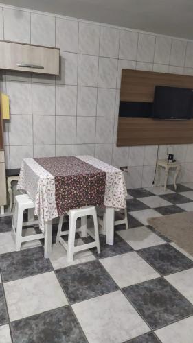 - une table et des chaises dans une cuisine dotée de carrelage dans l'établissement AP 35, à Praia Grande