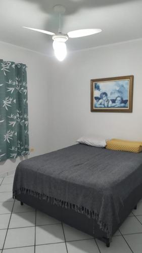 - un lit dans une chambre avec une photo sur le mur dans l'établissement AP 35, à Praia Grande