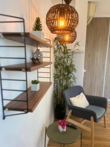 un salon avec une chaise et un lustre dans l'établissement Family apartment - terrace - parking - 4-5 people, à Antibes