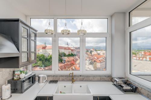 a kitchen with two sinks and two large windows at Grand Square Suite - Tale Of The City in Zagreb