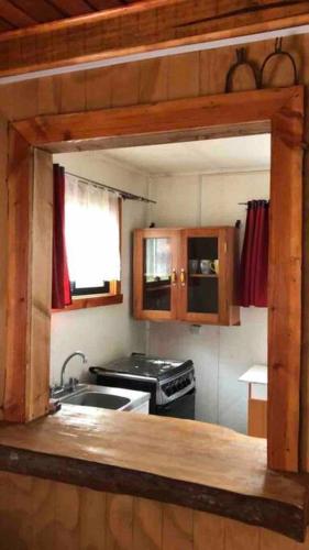 a kitchen with a sink and a stove at Arriendo casa en NELTUME a minutos de huilo-huilo in Neltume