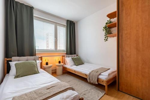 Un dormitorio con dos camas y una ventana. en Duna Retreat: City Serenity, en Bratislava