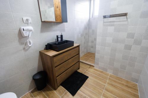 a bathroom with a black sink and a mirror at Apartman Paratetis 3 in Palić