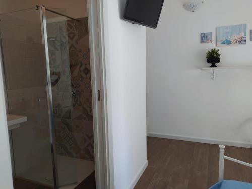 a shower with a glass door in a room at Dimora d'Estate (Sicilian Holidays) in Milazzo