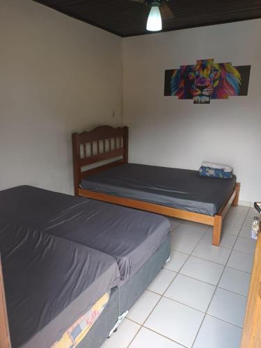 two beds sitting in a room with at Casa com Piscina na Morada da Praia in Bertioga