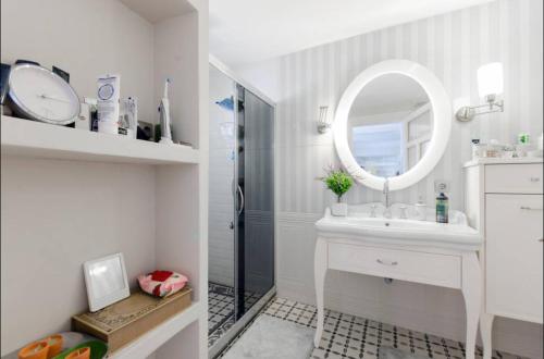 a white bathroom with a sink and a mirror at Ödüllü Tarihi Rum Evi Teraslı in Konak