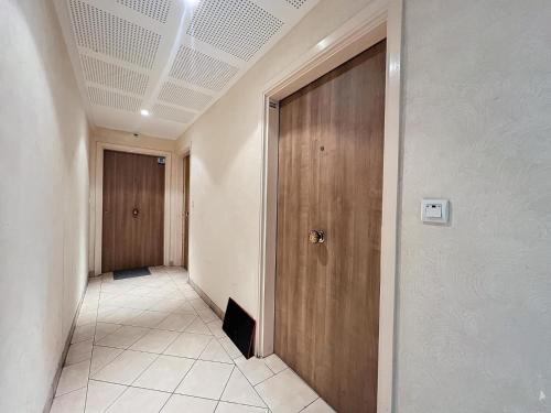 un couloir avec une porte en bois dans un bâtiment dans l'établissement Villa Pearl, à Nice