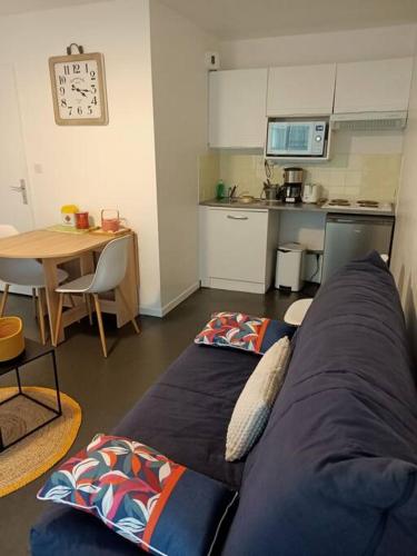 un salon avec un canapé bleu et une cuisine dans l'établissement Le Toutapieds, à Le Touquet-Paris-Plage