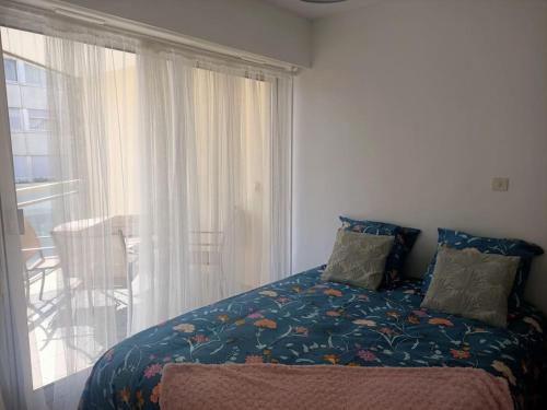 une chambre avec un lit et une grande fenêtre dans l'établissement Le Toutapieds, à Le Touquet-Paris-Plage