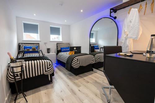Zimmer mit 2 Betten und einem Spiegel in der Unterkunft Exclusive Boutique Suites in Wigan
