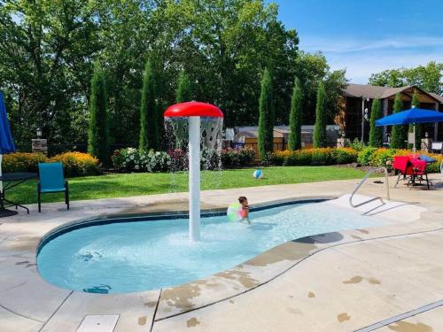 a person in a pool with a red umbrella at The Lake Fish-Amazing Views-Sleeps 24-indoor-outdoor pools in Branson