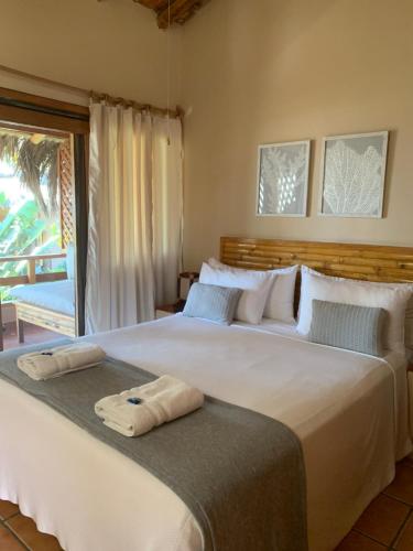 een slaapkamer met 2 bedden en handdoeken. bij Los Corales in Máncora