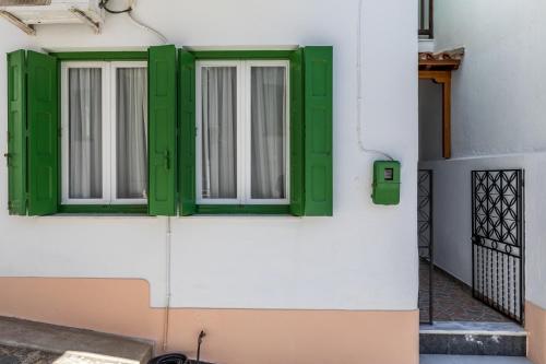 a window with green shutters on a white building at Sofia's House - Skopelos Town in Skopelos Town
