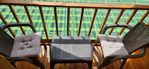 three chairs and a table on a balcony at Cabaña el rincon de la abuela in Guasca