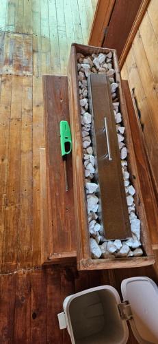 - une boîte en bois avec une porte et des rochers dans l'établissement Cabaña el rincon de la abuela, à Guasca