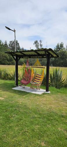 a gazebo with a group of colored chairs under it at Cabaña el rincon de la abuela in Guasca