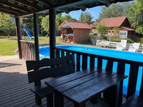 a wooden bench sitting on a deck next to a swimming pool at Łęgowska Dolina in Olecko