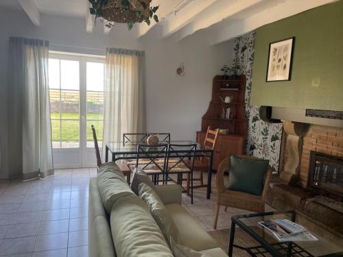 ein Wohnzimmer mit einem Sofa und einem Tisch in der Unterkunft Les gîtes du manoir de Port Cadic in Rédené