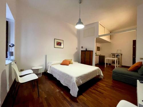 ein Schlafzimmer mit einem Bett, einem Stuhl und einem Sofa in der Unterkunft Suite Mamo in Palermo