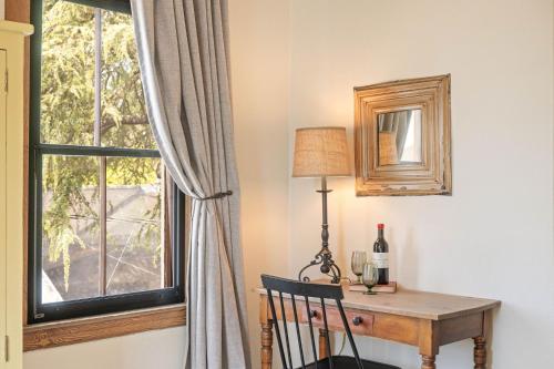 a desk with a window and a table with a bottle of wine at Sonoma Hotel in Sonoma
