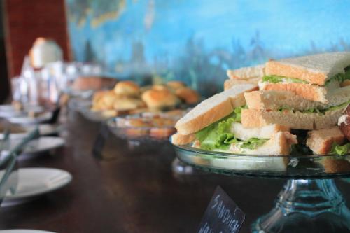 a table with a plate of sandwiches and donuts at Hotel Praia dos Carneiros in Tamandaré