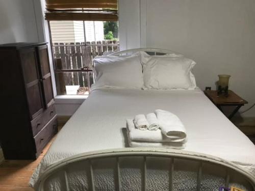 a large white bed with two towels on it at Acadiana Hideaway Tiny House in Lafayette