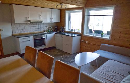 a kitchen with white cabinets and a table and chairs at Nordsjøvegen in Klepp