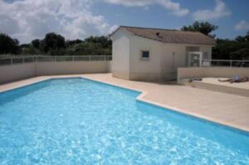une grande piscine bleue devant une maison dans l'établissement Beau T3 à Vaux sur mer, piscine été , parc , wifi , plage à 400 m, à Vaux-sur-Mer