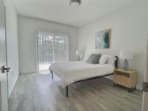 a white bedroom with a bed and a window at Sonoma Grove Suites in Sonoma