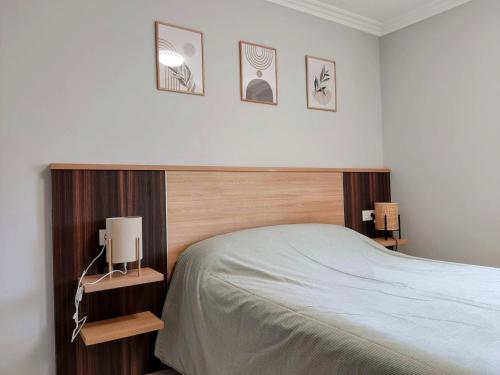 a bedroom with a bed and three pictures on the wall at Apartamento en Fisterra con vistas al mar, 3º sin ascensor in Fisterra