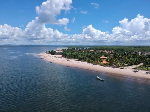 Casa a Beira mar na Barra do Serinhaem Ituberá - Bahia - Brasil في Sirinhaém: اطلالة جوية على شاطئ مع قارب في الماء