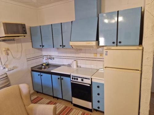 uma cozinha com armários azuis e um frigorífico branco em Urbanización la marina San Fulgencio 17 em San Fulgencio