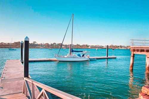 a sailboat is docked at a dock in the water at Augusta Budget Motel in Port Augusta