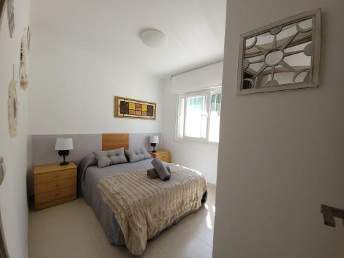 a bedroom with a bed and a mirror on the wall at Chalet adosado acogedor Busot in Alicante