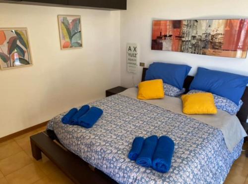 una camera da letto con un letto con cuscini blu e gialli di FrancisHouse-Free parking-Close Hospital Cisanello a Pisa